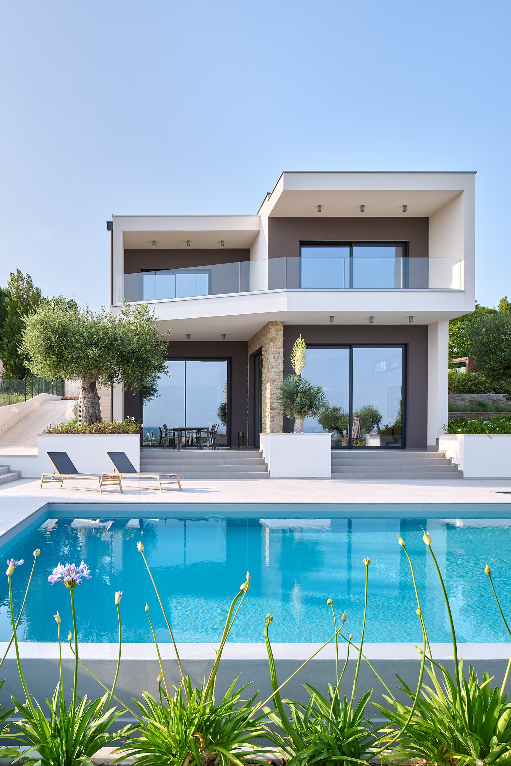 Villa su tre livelli con piscina, ulivo e grandi vetrate scorrevoli